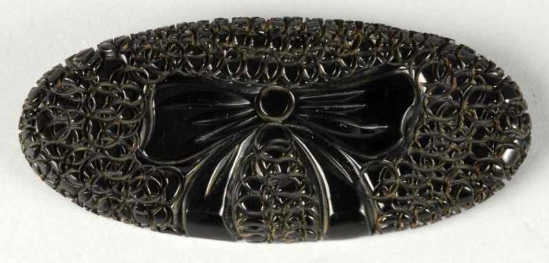 Appraisal: Bakelite Carved Bow Pin Description Cobblestone-type carving around bow Condition