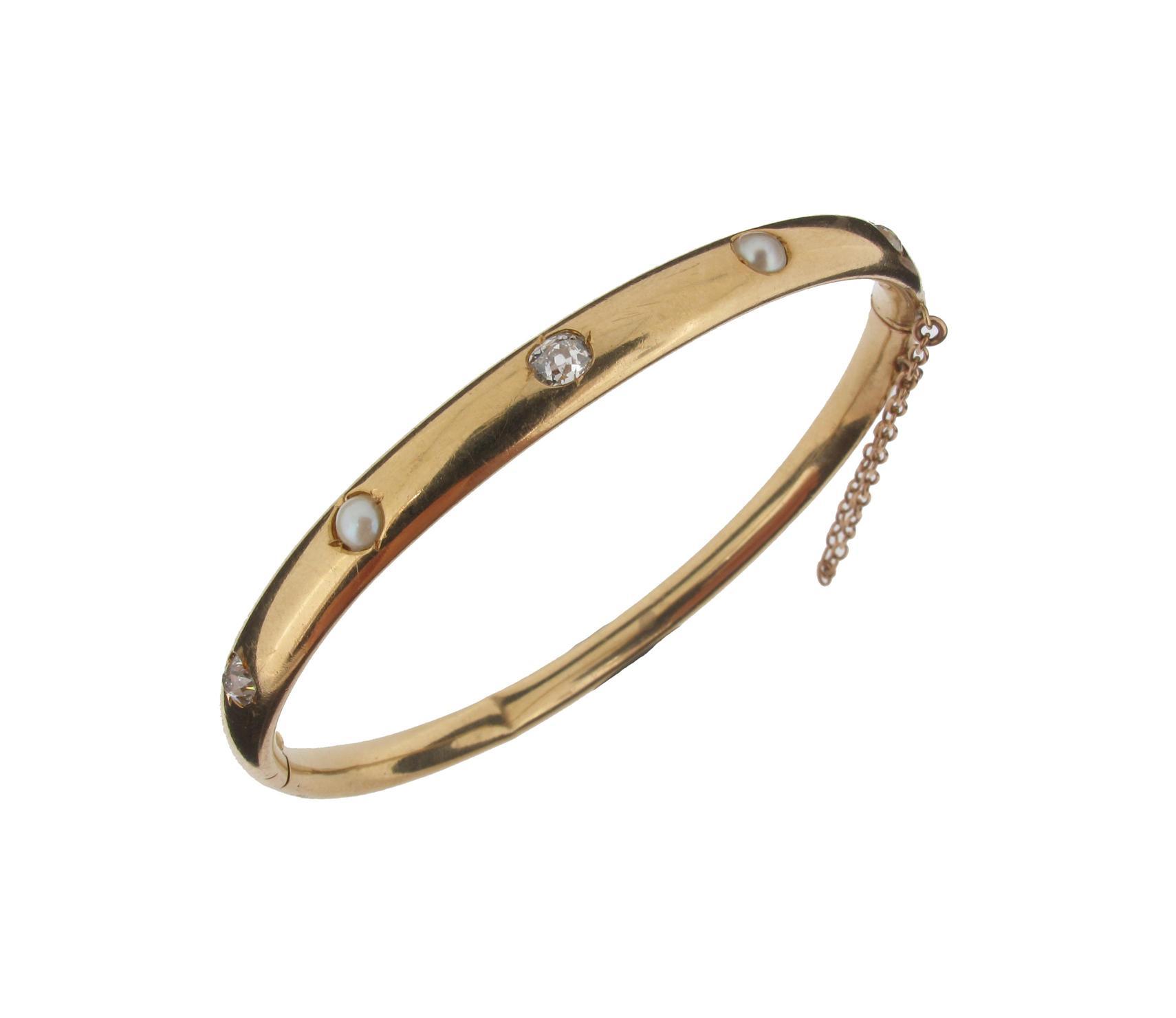 Appraisal: A gold hinged bangle set with three diamonds and two