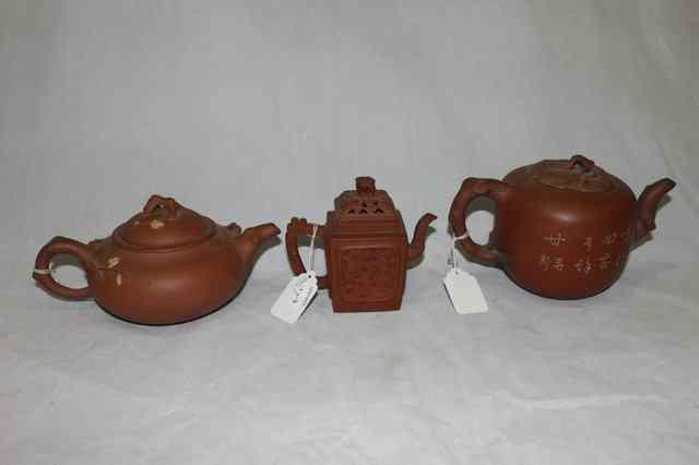 Appraisal: A CHINESE YIXING TEAPOT with inscription and leaf cover a