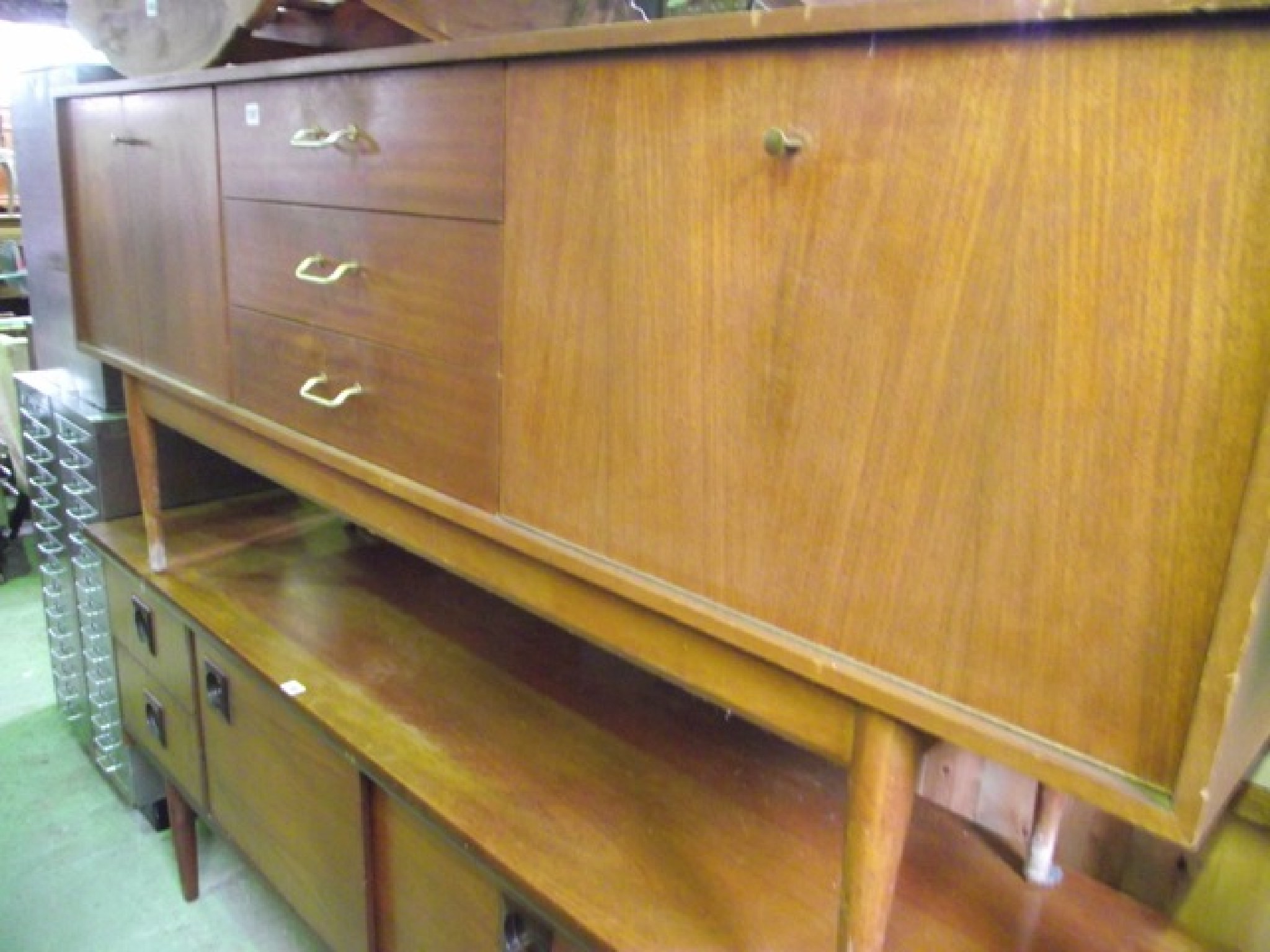 Appraisal: A mid th century long and low teak Uniflex sideboard