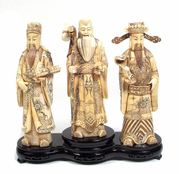 Appraisal: A set of three carved bone veneer and enameled figures