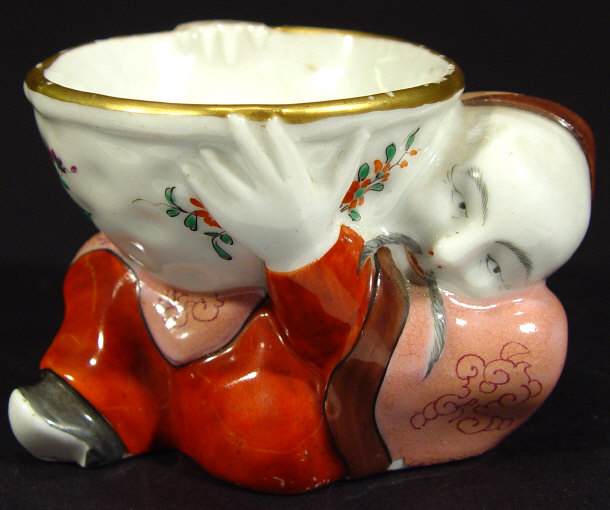 Appraisal: Samson china salt supported by an oriental figure the bowl