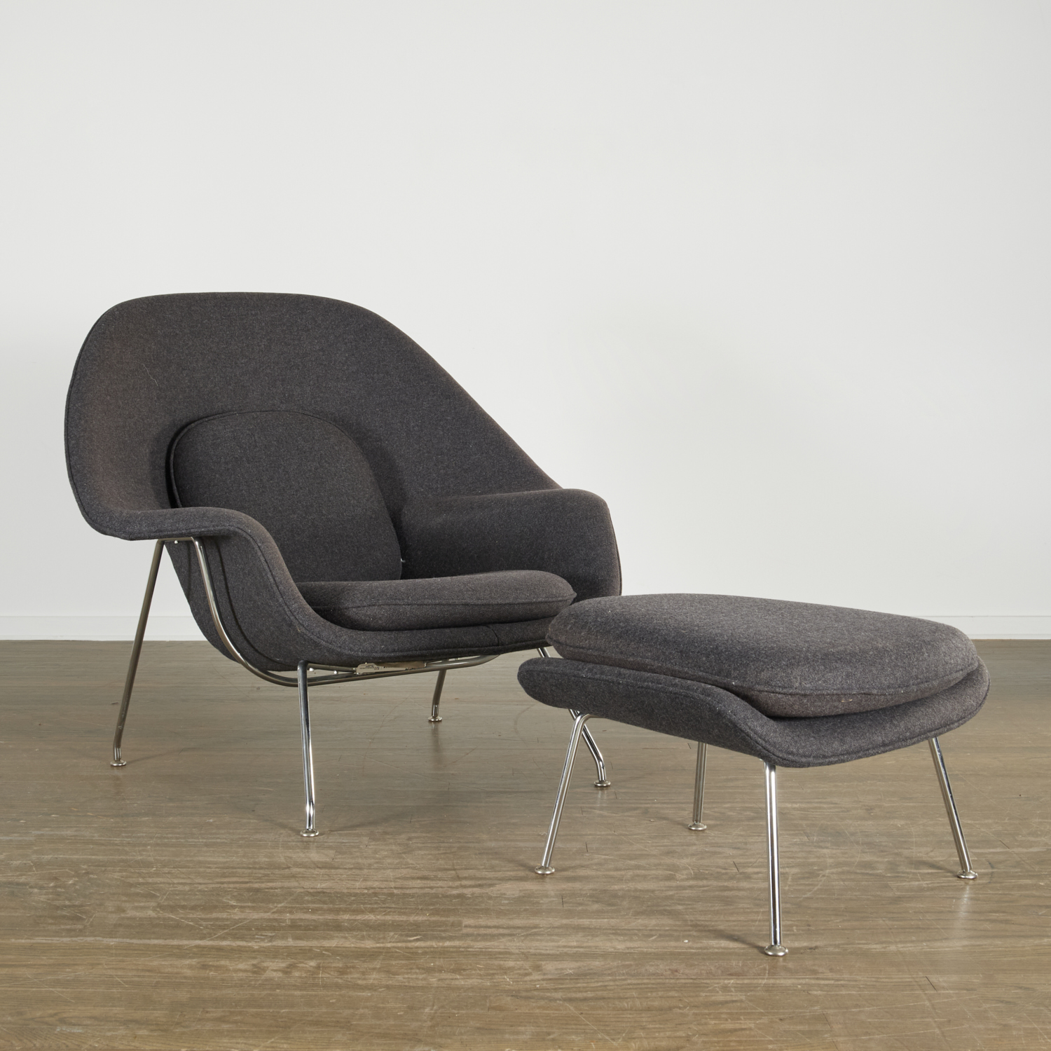 Appraisal: EERO SAARINEN WOMB CHAIR AND OTTOMAN Introduced American chrome-plated steel