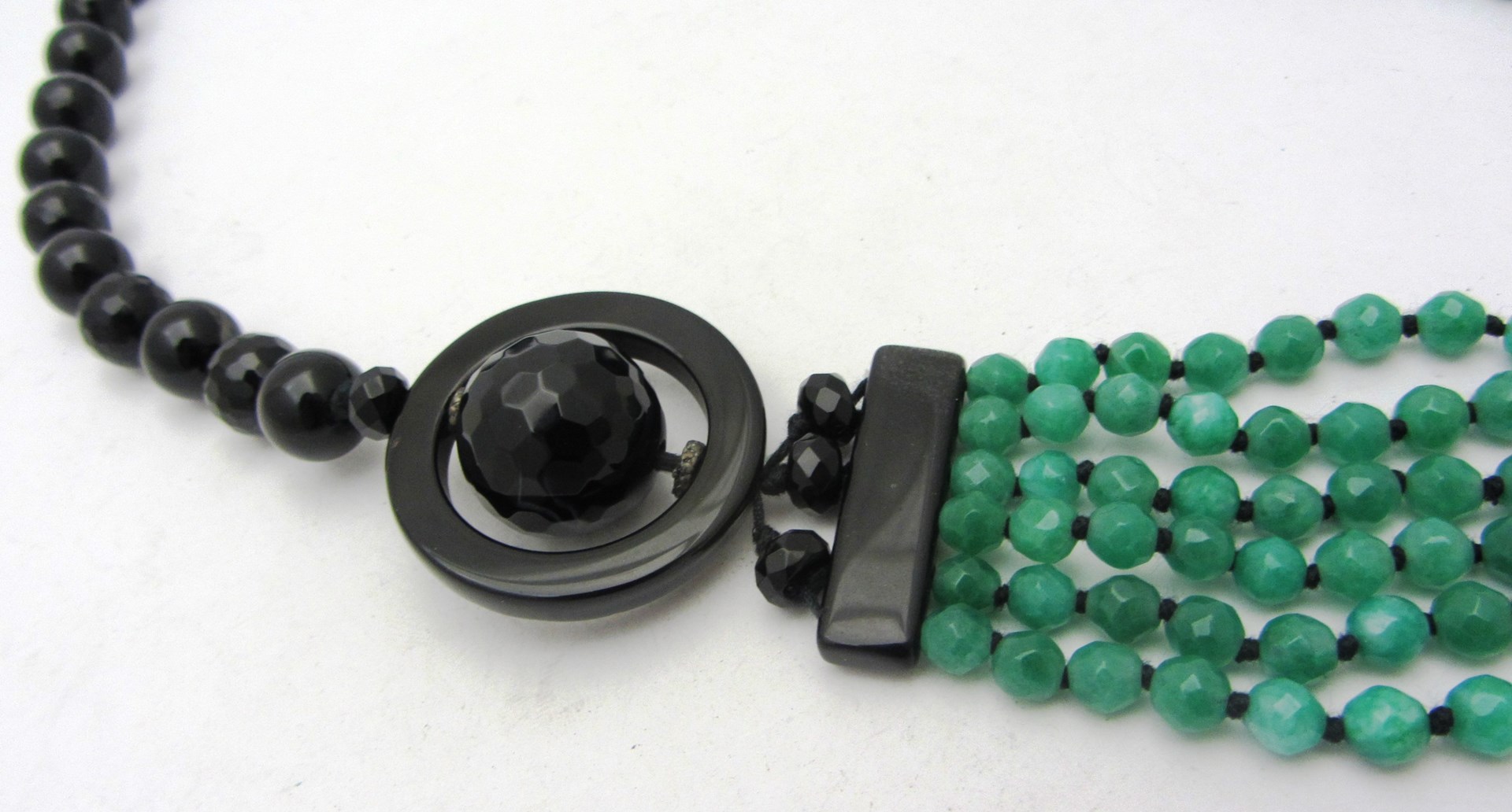 Appraisal: A black onyx and faceted six row green stone bead