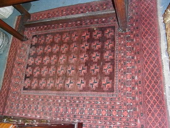 Appraisal: A RED GROUND ORIENTAL RUG with central panel and multiple