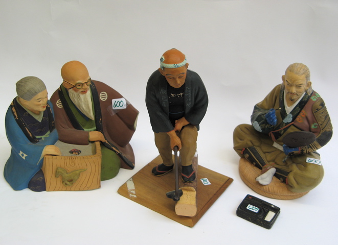 Appraisal: THREE JAPANESE PAINTED POTTERY FIGURES an older man standing chopping