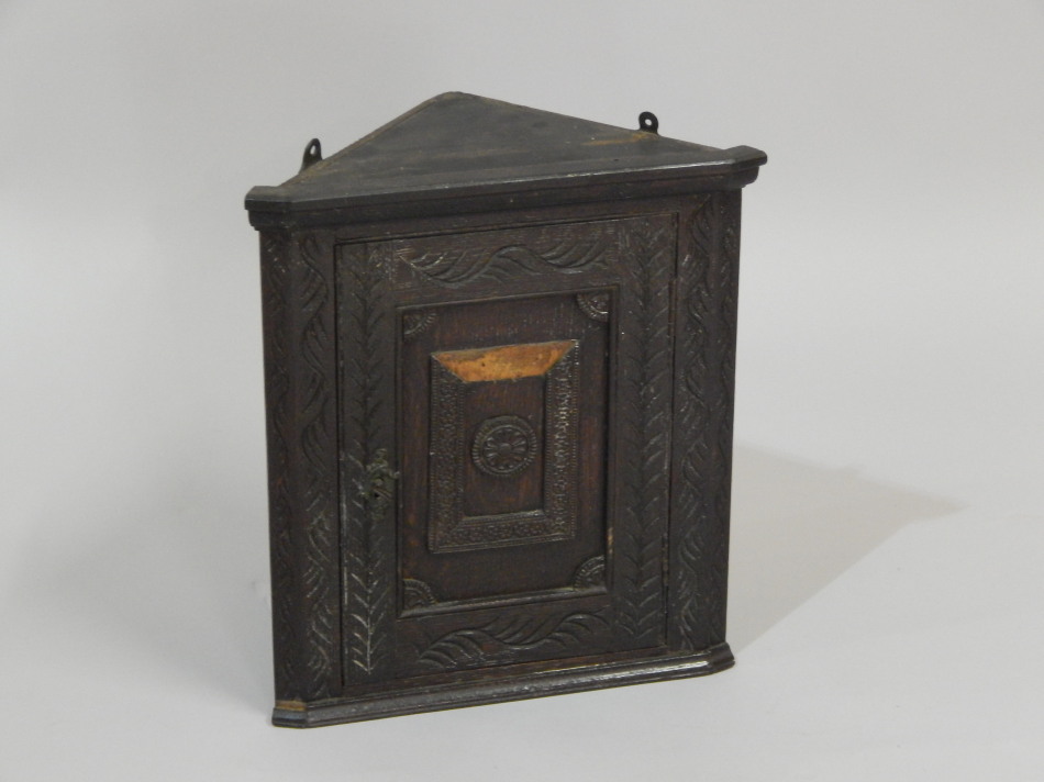 Appraisal: An early thC dark oak small hanging corner cabinet with