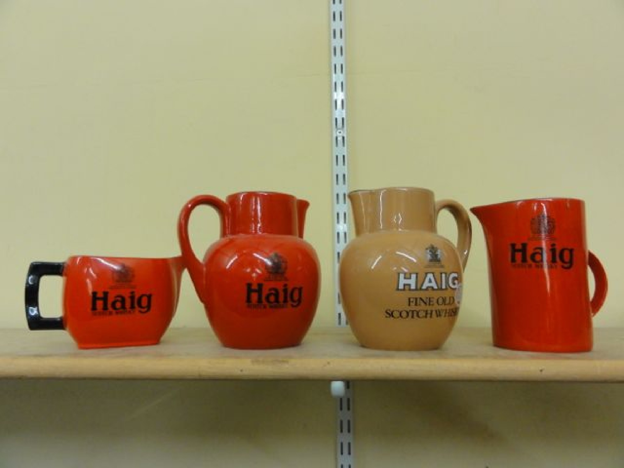 Appraisal: Three red ground Carlton ware jugs inscribed Haig Scotch whisky