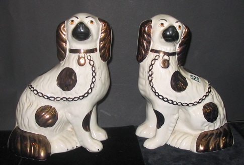 Appraisal: PAIR OF ENGLISH STAFFORDSHIRE POTTERY SPANIELS copper lustre accents on