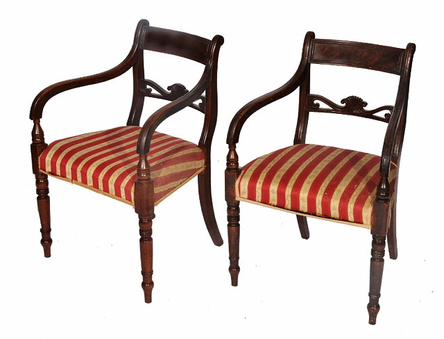 Appraisal: A PAIR OF REGENCY MAHOGANY ARMCHAIRS with carved horizontal splat