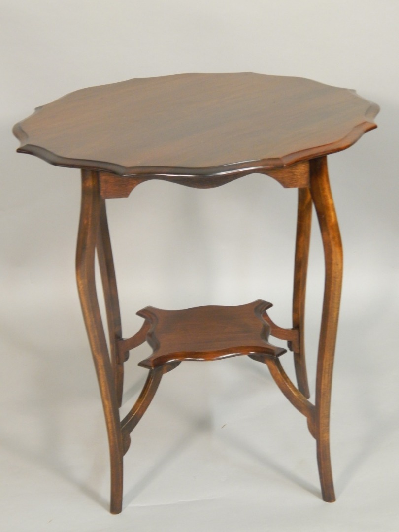 Appraisal: An Edwardian mahogany occasional table the top with a serpentine