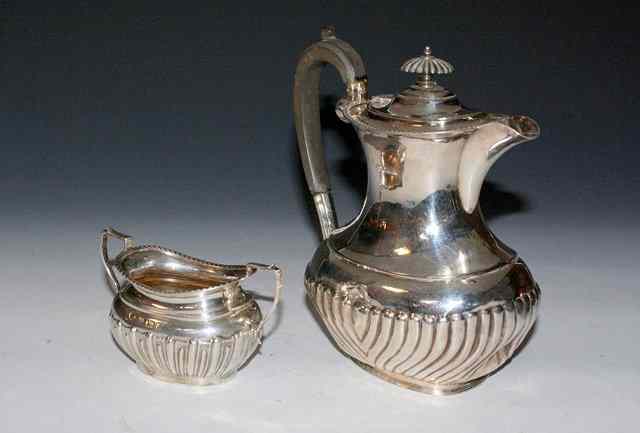 Appraisal: A SILVER HOT WATER JUG of waisted form with fluted