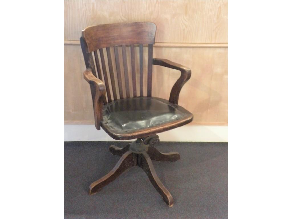 Appraisal: An Edwardian oak revolving office chair on four swept legs