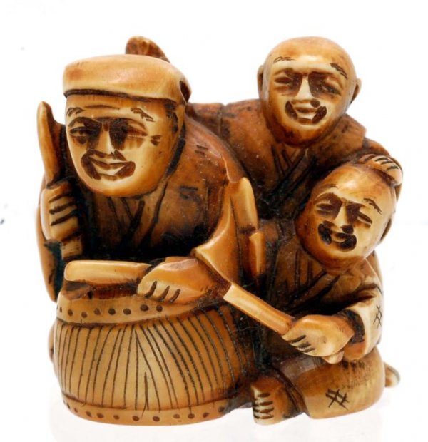 Appraisal: An ivory netsuke figural grouping of three figures one playing