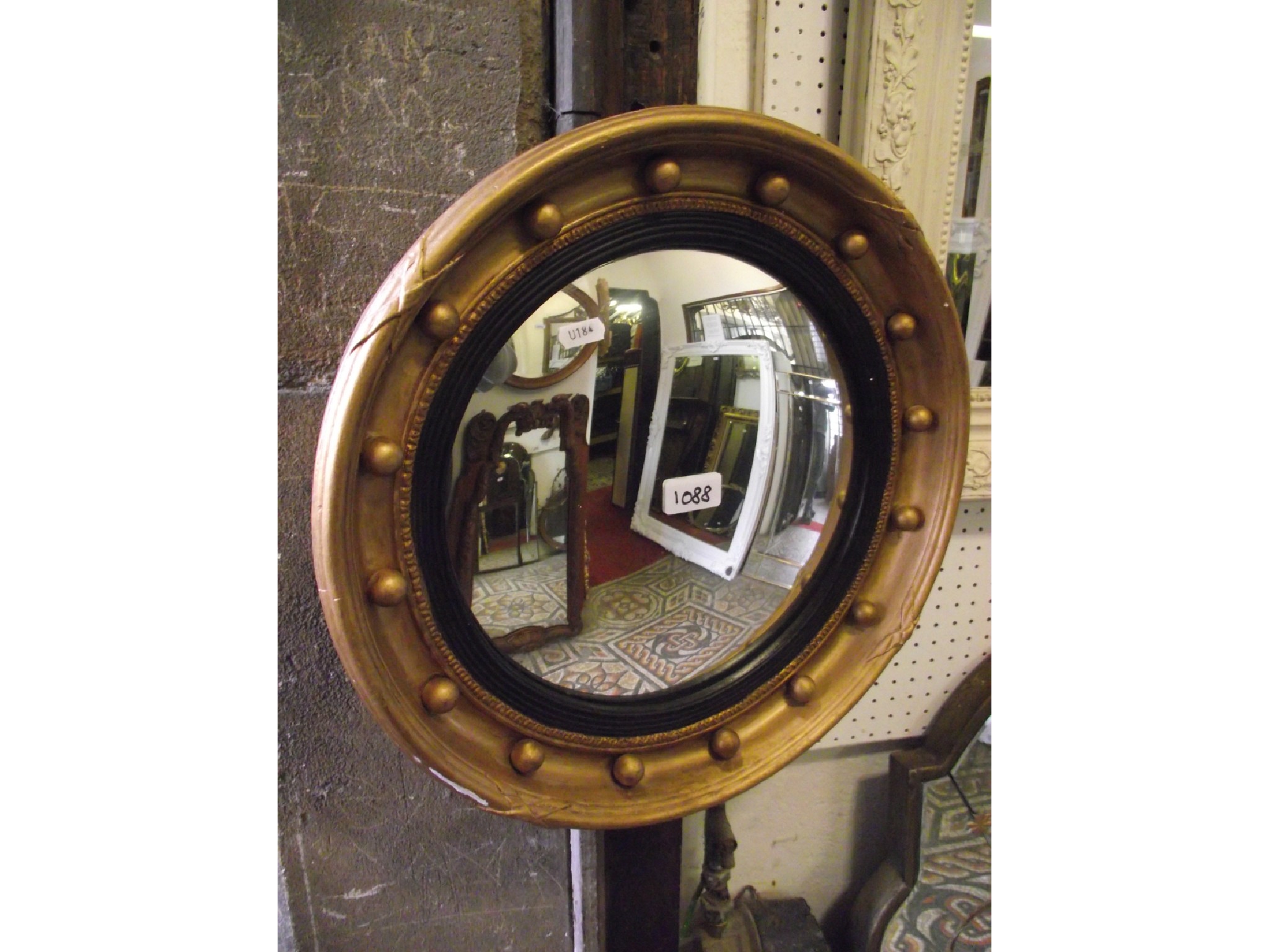 Appraisal: A Regency style convex wall mirror with reeded ebonised slip