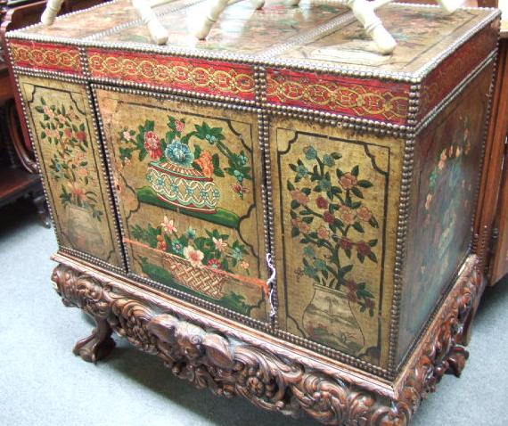 Appraisal: A gilt and polychrome decorated leather cabinet on carved oak