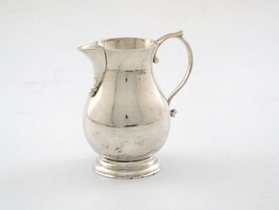 Appraisal: A silver cream jug plain baluster form scroll handle on