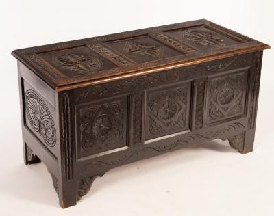 Appraisal: An early th Century carved oak chest with triple-panel hinged