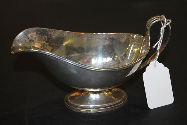 Appraisal: A SILVER SAUCE BOAT with reeded border and oval pedestal