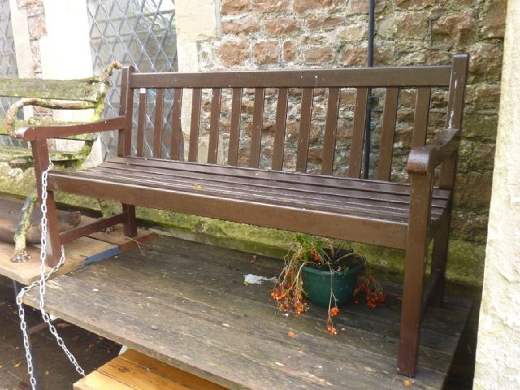 Appraisal: A stained hardwood three seat garden bench with slatted seat