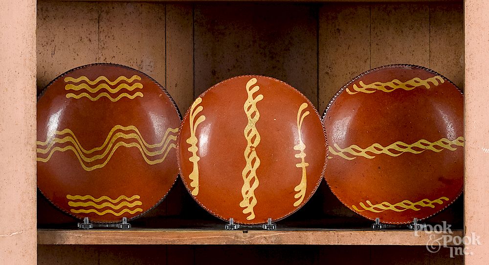 Appraisal: Three Pennsylvania redware plates Three Pennsylvania redware plates th c