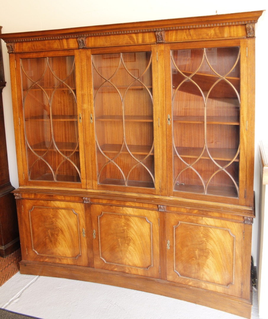 Appraisal: A modern mahogany finish display cabinet of curved outline the