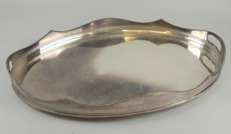 Appraisal: A silver plated oval tray with a beaded pierced gallery