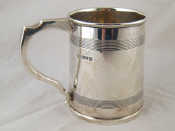 Appraisal: A silver tankard with plain ribbed bandsin the Georgian style