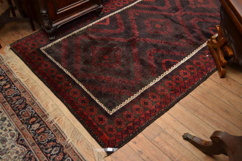 Appraisal: A BLACK BALUCH PILE RUG IN RED BLACK AND BLUE