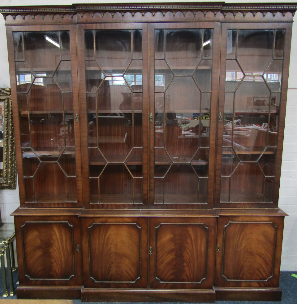 Appraisal: A mahogany breakfront bookcase the dentil moulded pediment over four