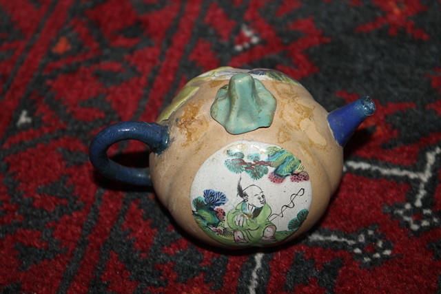 Appraisal: A YIXING MINIATURE TEAPOT with two enamel panels decorated with