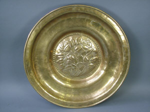 Appraisal: An Arts and Crafts embossed brass charger by Hugh Wallis