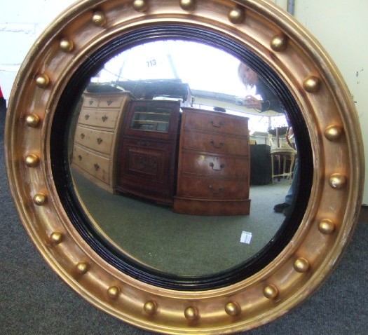 Appraisal: A Regency gilt framed convex wall mirror with ball decoration