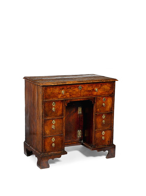 Appraisal: A GEORGE I WALNUT KNEEHOLE DESK fitted with an arrangement