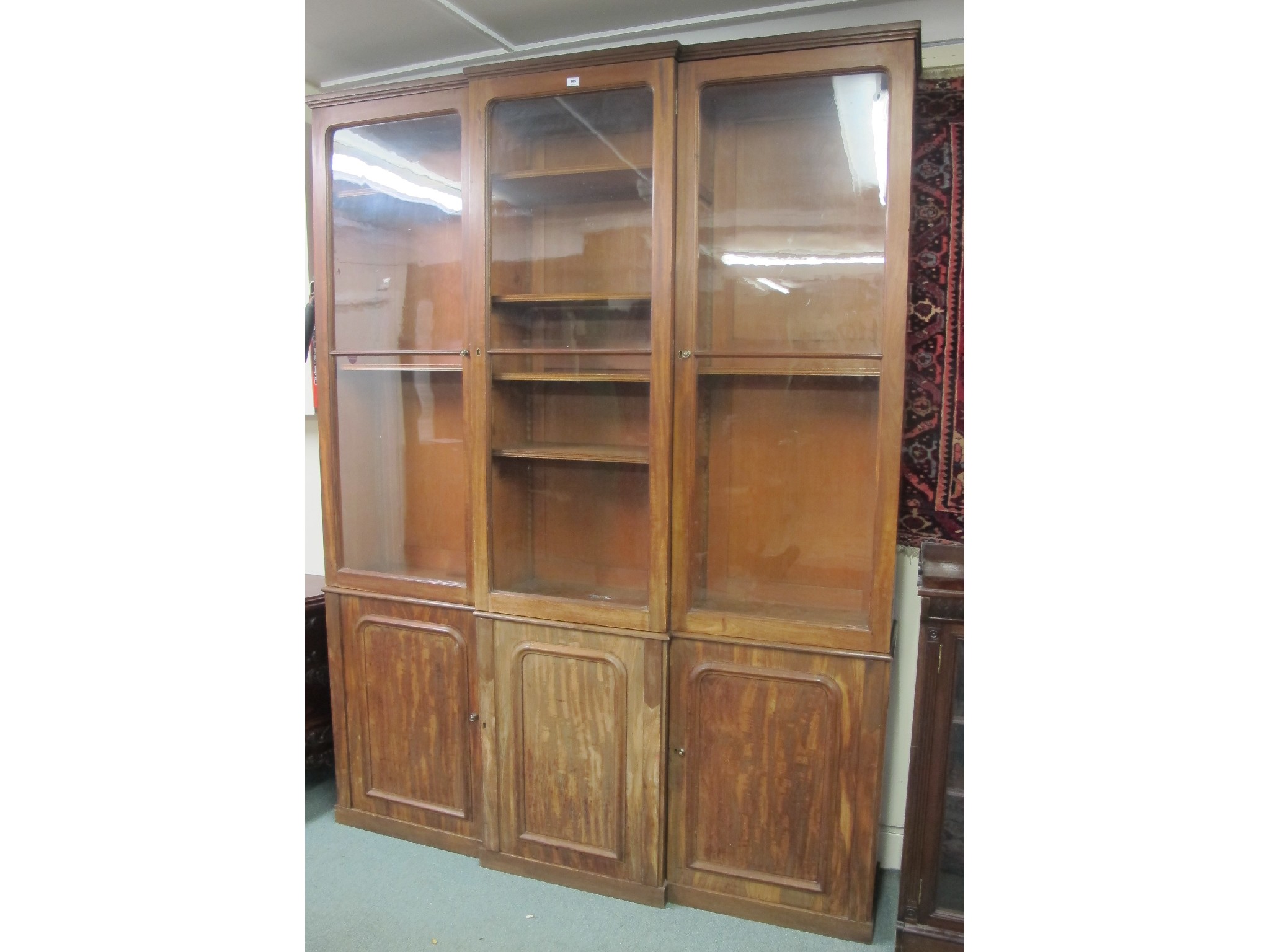 Appraisal: Victorian mahogany glazed three door bookcase on cupboard base