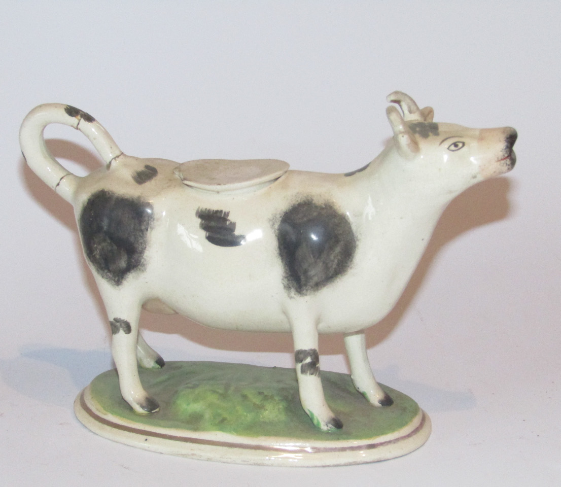 Appraisal: A mid- thC Staffordshire cow creamer with tail handle and