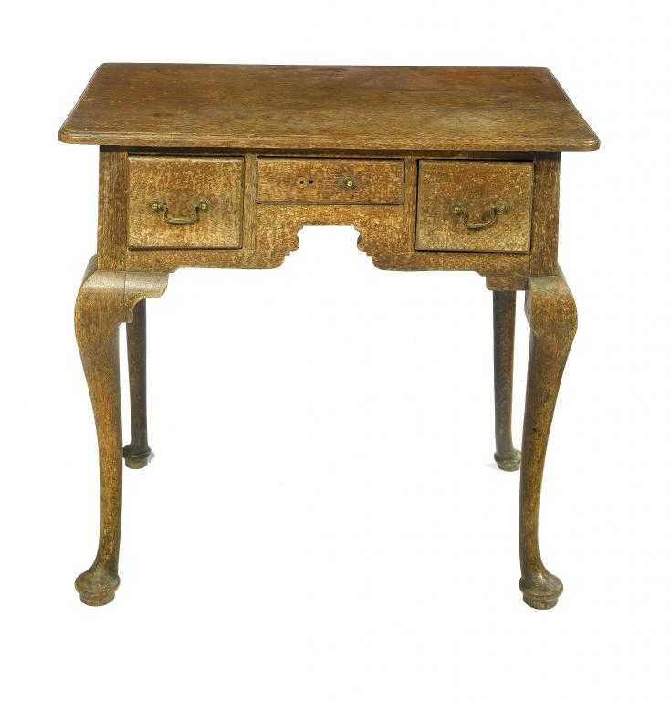 Appraisal: A GEORGE III OAK LOWBOY the moulded top with rounded