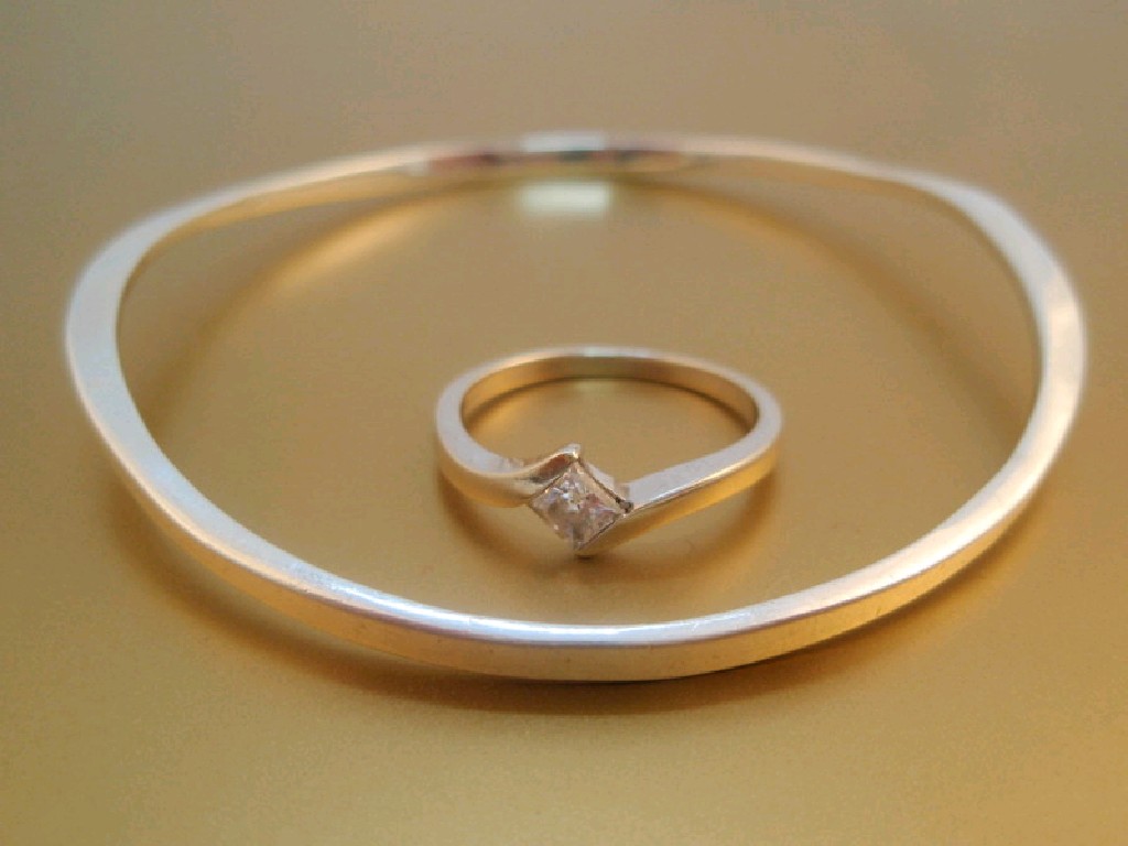 Appraisal: A white metal wave bangle together with a princess cut