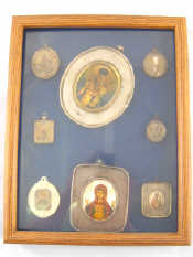 Appraisal: A display case containing eight icons in silver rizas two