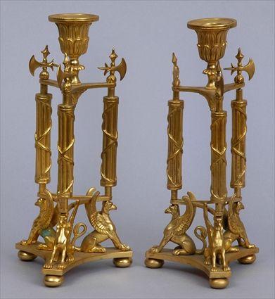 Appraisal: PAIR OF EMPIRE-STYLE GILT BRONZE CANDLESTICKS Each tiered leaf nozzle