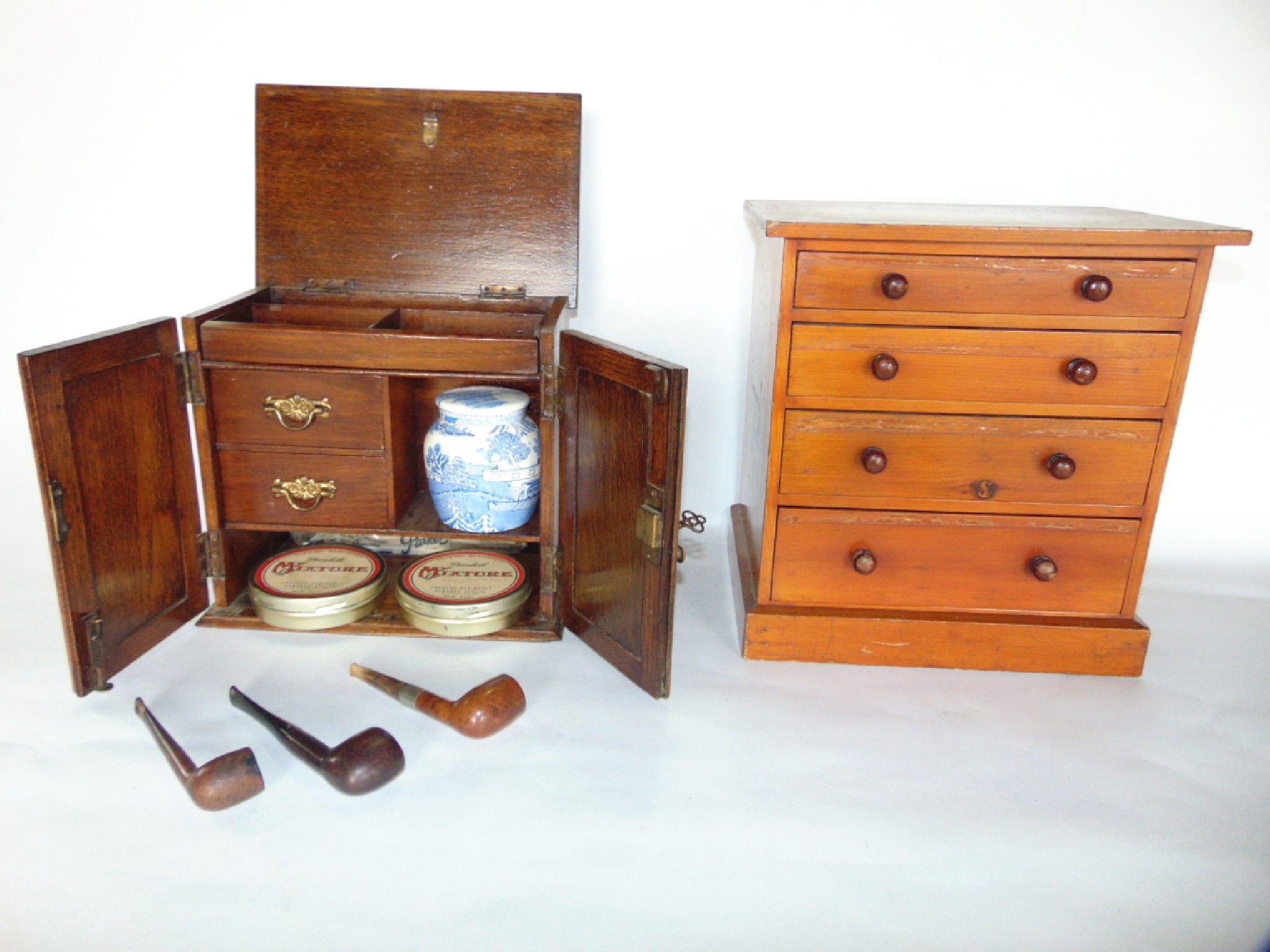 Appraisal: A vintage stained pine miniature bank of four graduating drawers