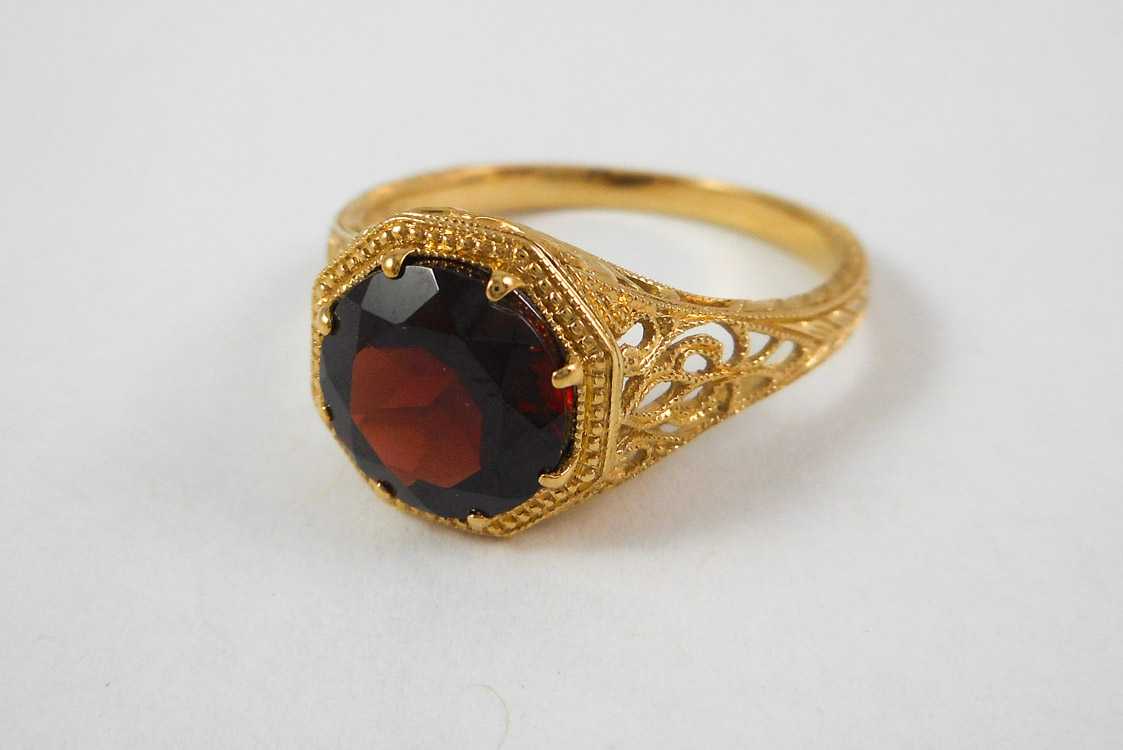 Appraisal: GARNET AND FOURTEEN KARAT GOLD RING the yellow gold filigree