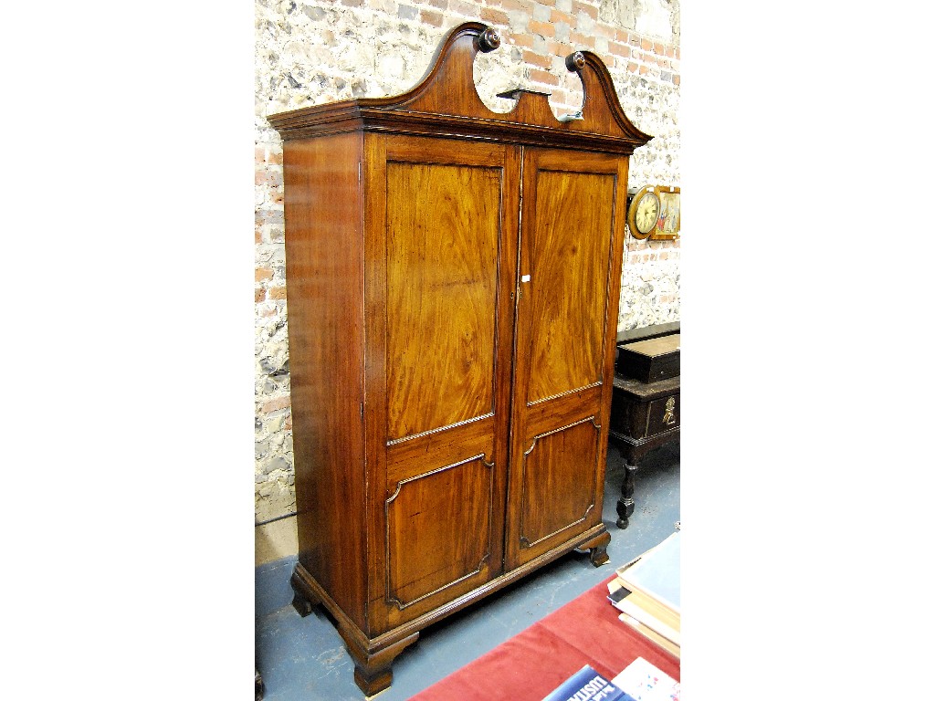 Appraisal: George III mahogany cupboard the broken arched canopy over a