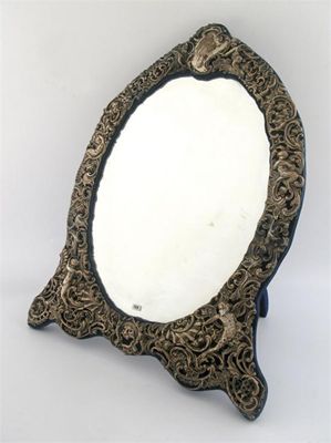 Appraisal: An Edwardian mounted easel mirror of shaped oval outline the