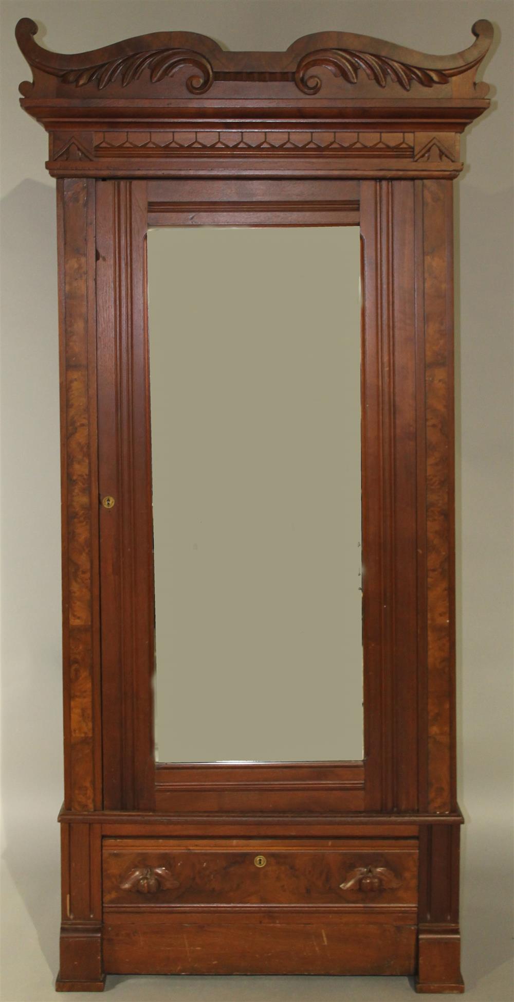 Appraisal: EASTLAKE STYLE WALNUT WARDROBE having a carved pediment over a