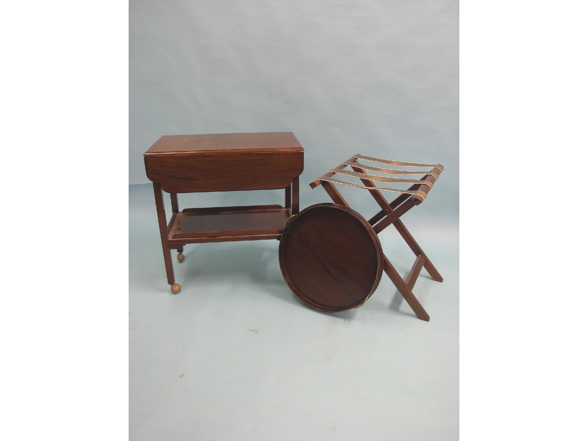 Appraisal: A mahogany drop-leaf trolley circular mahogany tray with brass handles