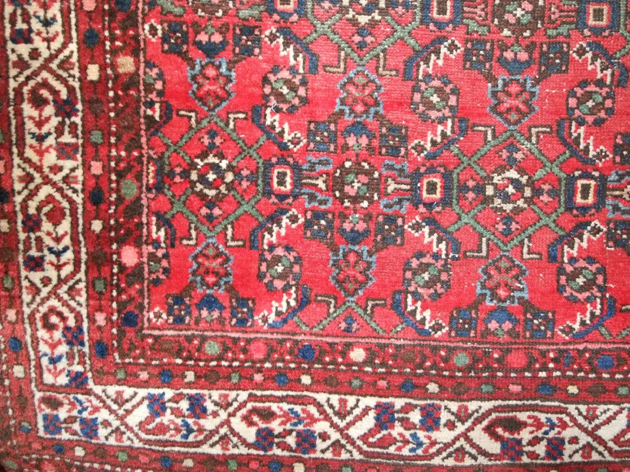 Appraisal: An eastern wool rug with red field geometric detail set