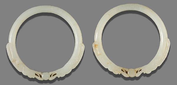 Appraisal: A pair of white jade dragon bracelets Each identically carved