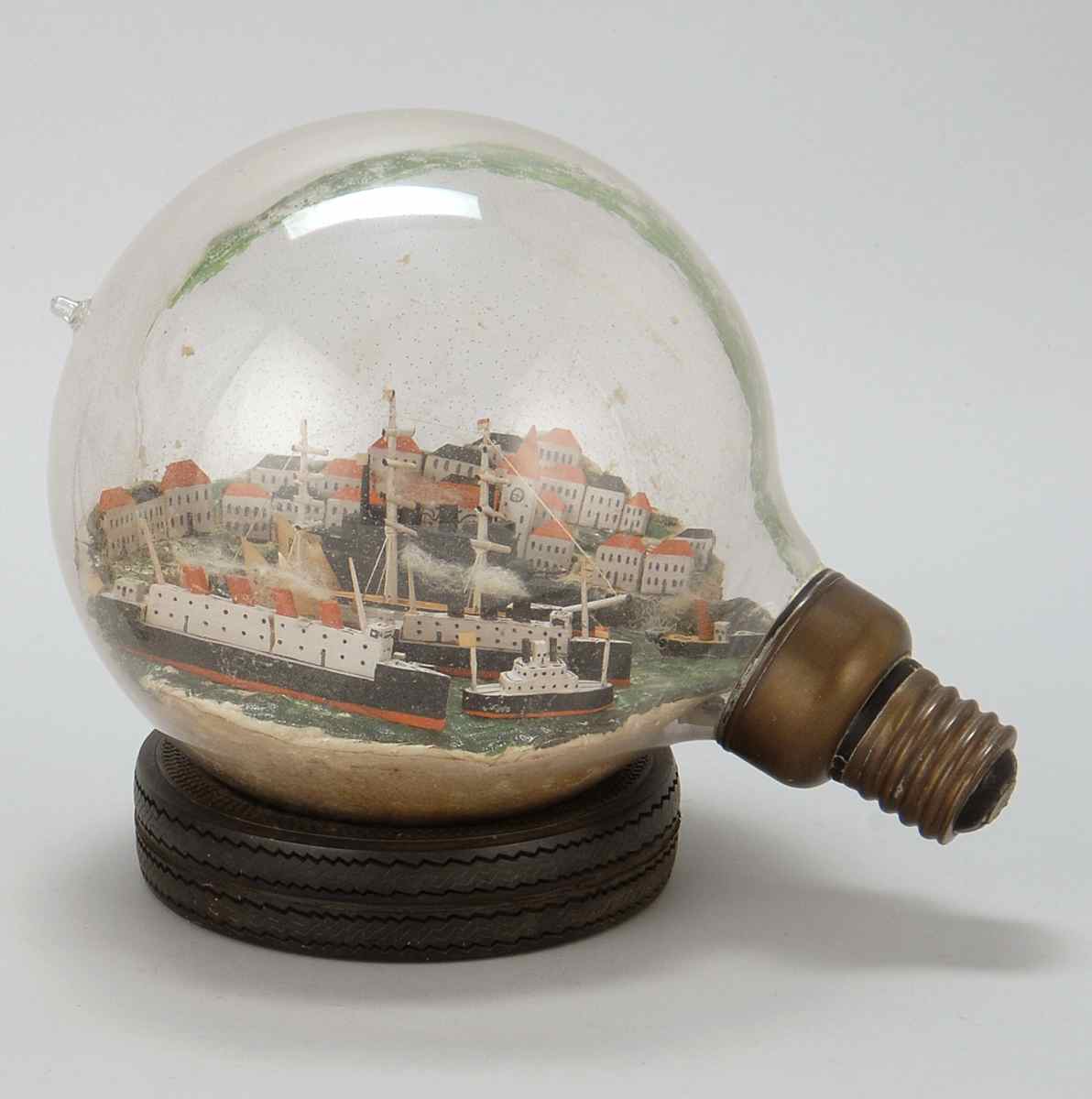 Appraisal: SHIP-IN-A-LIGHTBULB Large lightbulb containing a diorama with a coastal village