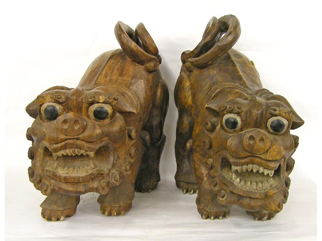 Appraisal: Two similar large Chinese carved wooden crouching Buddhistic startled lions